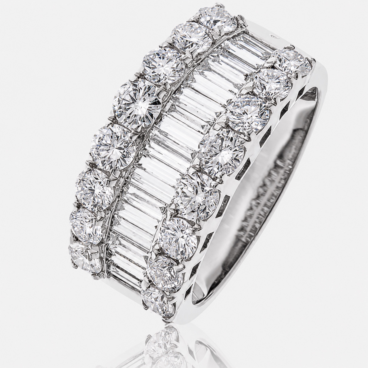 A wide 18ct white gold diamond ring with a central channel of baguette-cut diamonds flanked by rows of round brilliants